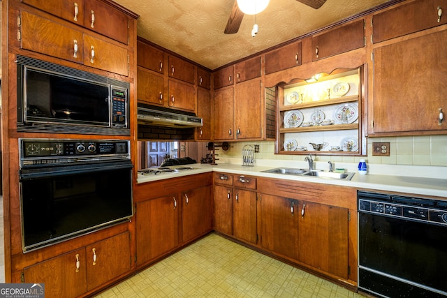 kitchen featuring light floors, under cabinet range hood, a sink, light countertops, and black appliances