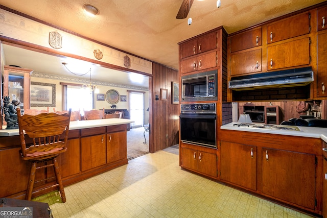 kitchen featuring light floors, white cooktop, built in microwave, oven, and under cabinet range hood