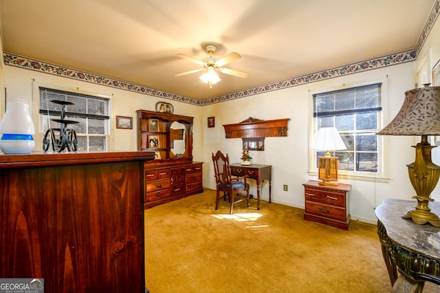 carpeted office featuring baseboards and a ceiling fan