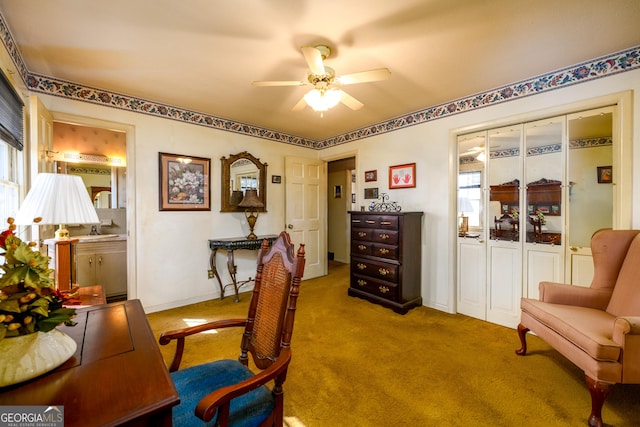 carpeted office space featuring a wealth of natural light, ceiling fan, and baseboards