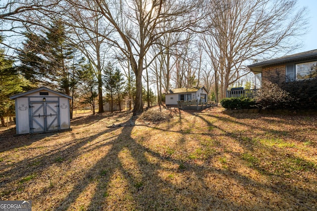 view of yard with a storage shed, a deck, and an outdoor structure