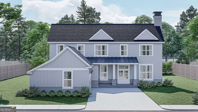 view of front facade with brick siding, fence, french doors, a standing seam roof, and a front yard