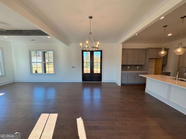 interior space with a wealth of natural light, dark wood finished floors, and beam ceiling