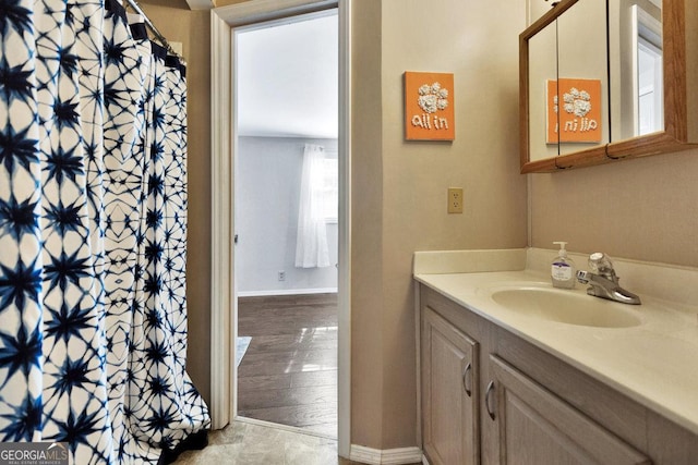 full bath with curtained shower, baseboards, wood finished floors, and vanity