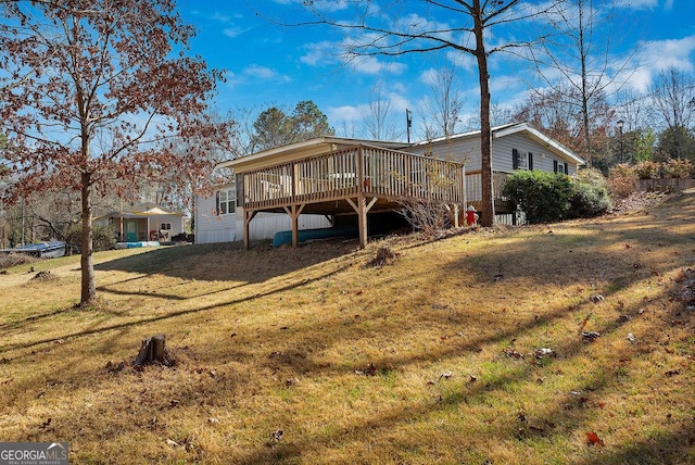 rear view of house with a deck and a lawn