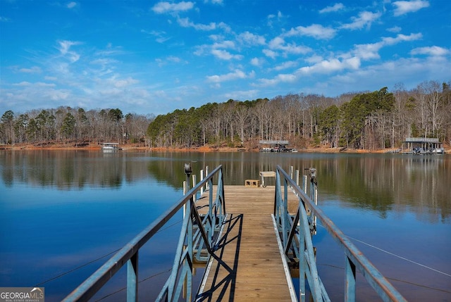 dock area with a water view and a wooded view