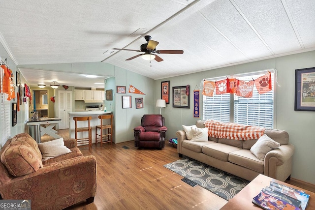 living area with lofted ceiling, ceiling fan, ornamental molding, a textured ceiling, and light wood-type flooring