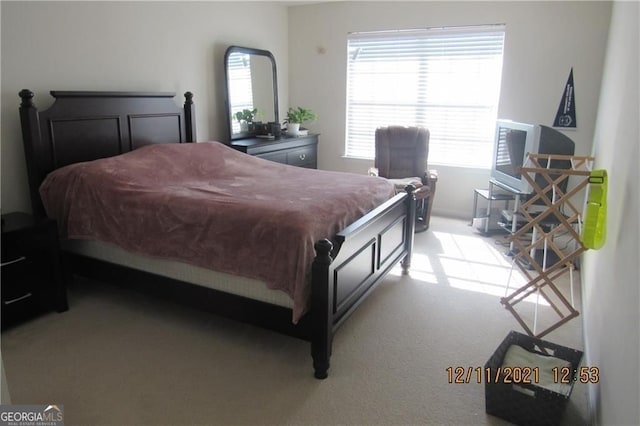 bedroom with light carpet and multiple windows