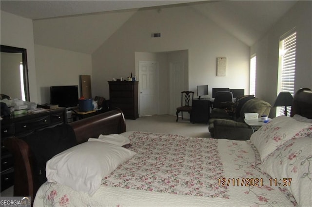 carpeted bedroom with high vaulted ceiling and visible vents