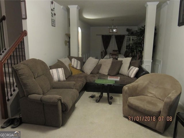 carpeted living area featuring stairs and ornate columns