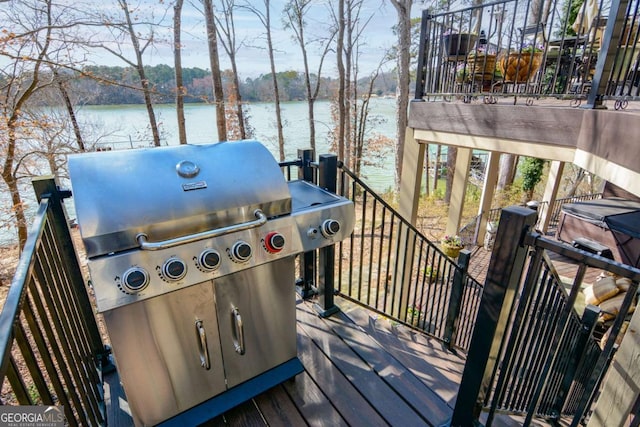 wooden deck with a water view and a grill