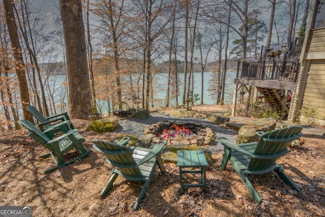 view of yard featuring a water view, an outdoor fire pit, and stairs