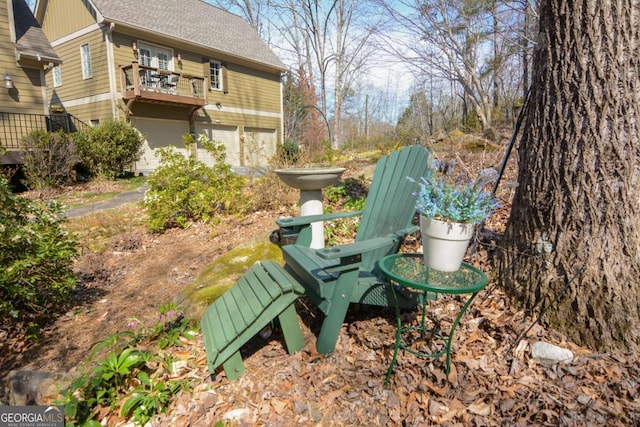 view of yard featuring a balcony and an attached garage