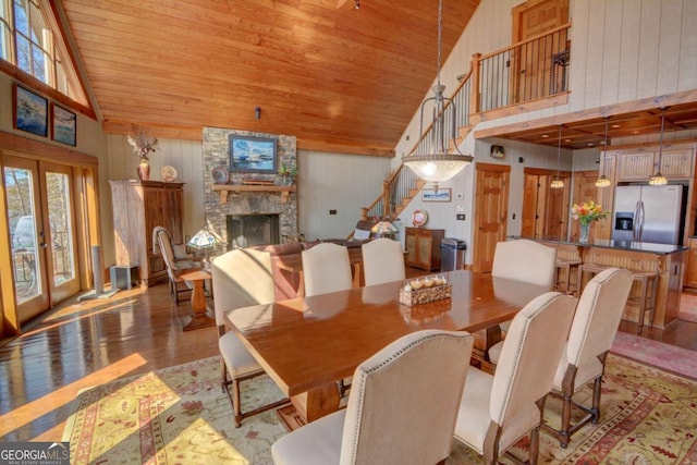 dining room with wooden ceiling, a fireplace, stairway, and wood finished floors