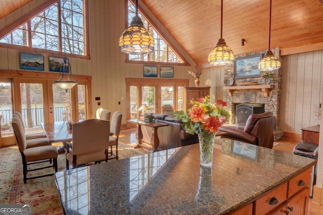 dining room with high vaulted ceiling, french doors, wooden ceiling, and wood walls