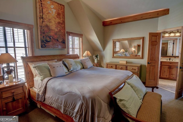 bedroom with lofted ceiling with beams and light colored carpet