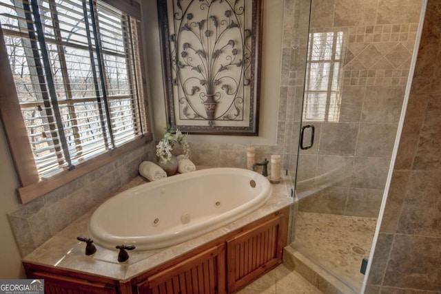 full bath featuring a jetted tub, a shower stall, and tile patterned floors