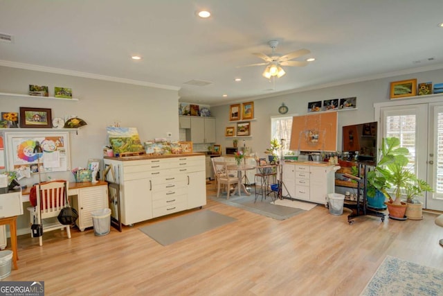 interior space with plenty of natural light, light wood-style flooring, and crown molding