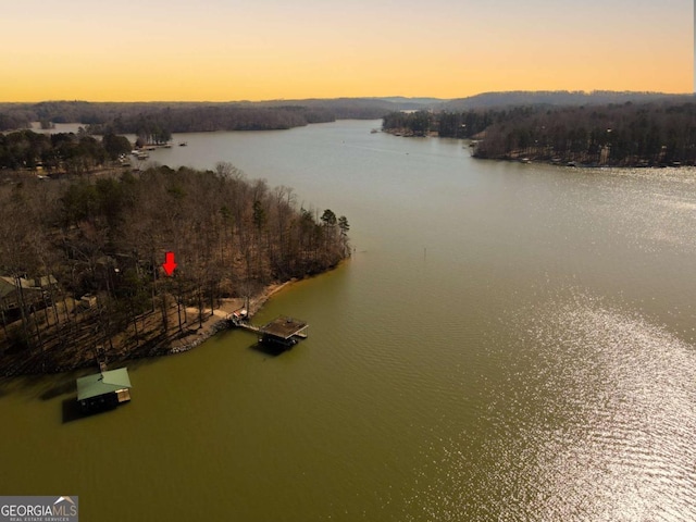 aerial view at dusk featuring a water view