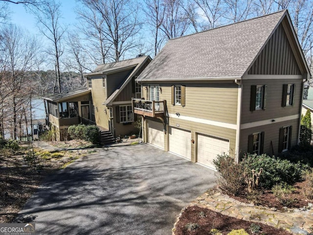 view of front of property with aphalt driveway, a sunroom, an attached garage, and board and batten siding