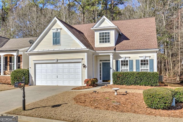 view of front of property featuring driveway, a garage, and roof with shingles