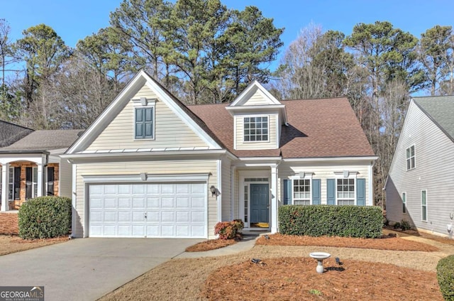 view of front of house featuring a garage, a shingled roof, and concrete driveway