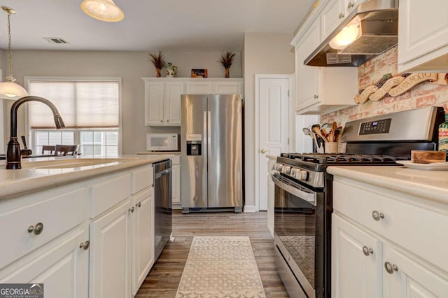 kitchen featuring stainless steel appliances, visible vents, white cabinets, a sink, and under cabinet range hood