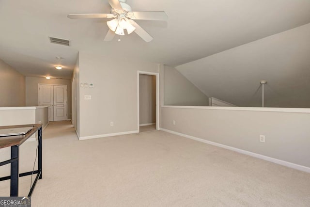 additional living space featuring light carpet, baseboards, visible vents, ceiling fan, and vaulted ceiling