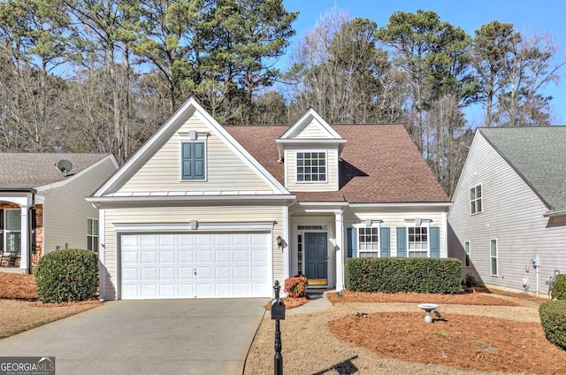 view of front of home with driveway, roof with shingles, and an attached garage