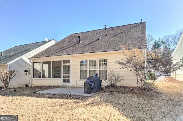 rear view of property featuring a patio, a shingled roof, and a sunroom