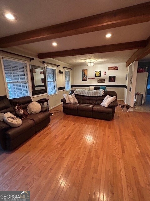 living area with light wood finished floors, baseboards, beamed ceiling, and recessed lighting