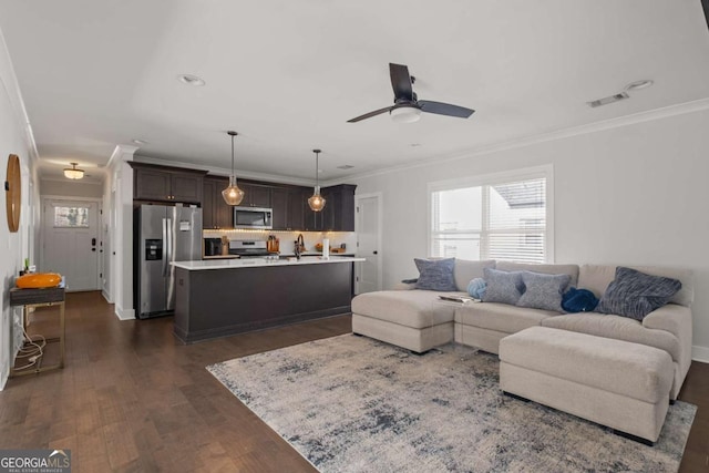 living room with dark wood-style floors, recessed lighting, visible vents, ornamental molding, and a ceiling fan