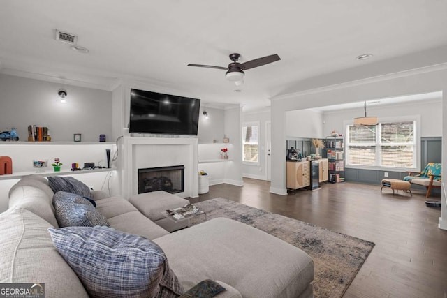 living room with crown molding, dark wood finished floors, visible vents, and a healthy amount of sunlight