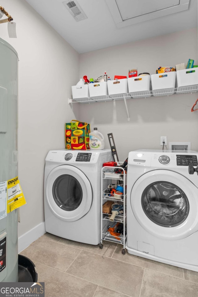 laundry room with laundry area, light tile patterned floors, visible vents, electric water heater, and washer and dryer