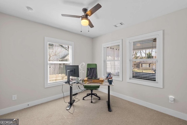 office area with a wealth of natural light, baseboards, visible vents, and carpet flooring