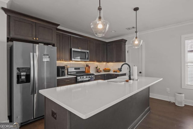 kitchen featuring stainless steel appliances, a sink, visible vents, ornamental molding, and tasteful backsplash