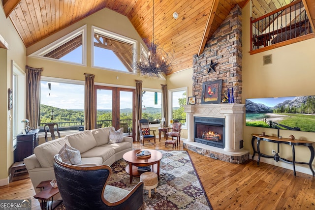 living area with visible vents, wooden ceiling, hardwood / wood-style flooring, a fireplace, and a notable chandelier