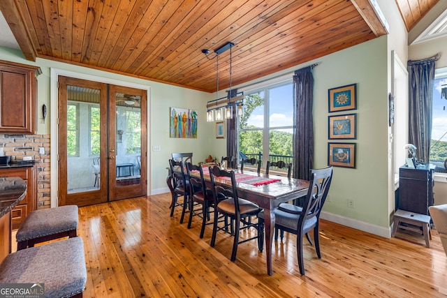 dining room featuring wood ceiling, baseboards, light wood-style flooring, and french doors