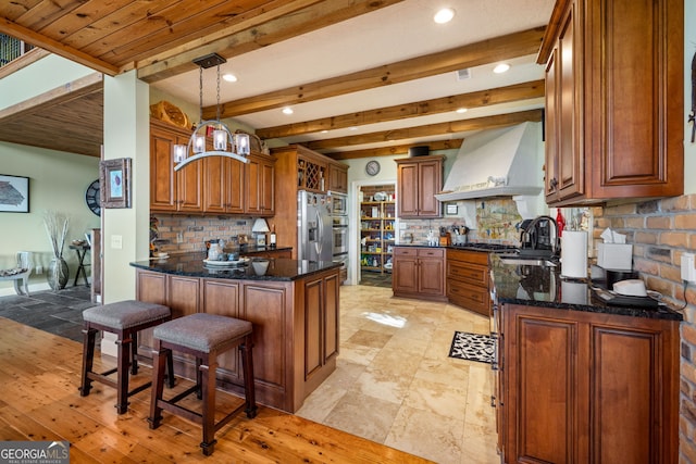 kitchen featuring stainless steel appliances, a peninsula, a sink, custom exhaust hood, and decorative backsplash