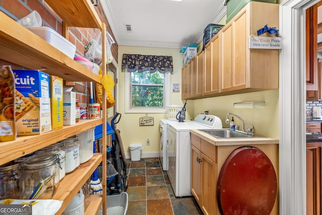 washroom featuring separate washer and dryer, a sink, baseboards, ornamental molding, and cabinet space