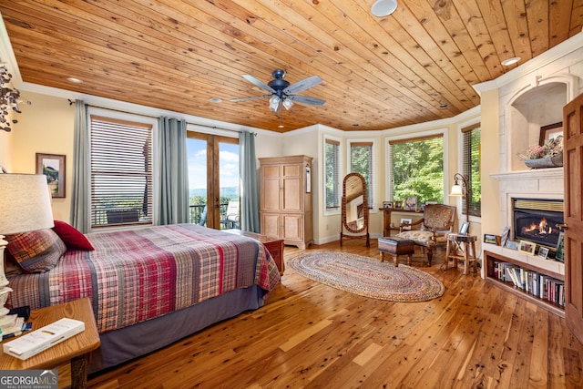 bedroom with a glass covered fireplace, wooden ceiling, wood-type flooring, and crown molding