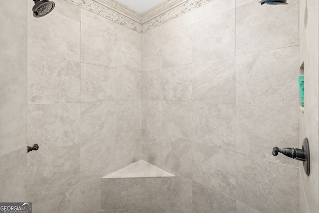 details featuring a tile shower and crown molding