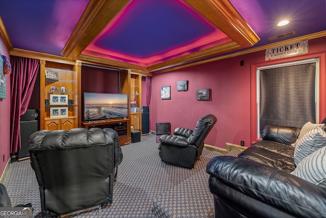 cinema room featuring carpet flooring, visible vents, baseboards, ornamental molding, and a raised ceiling