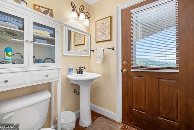 bathroom with toilet and baseboards