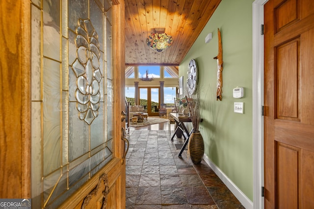 entryway with wooden ceiling, baseboards, vaulted ceiling, and stone tile flooring