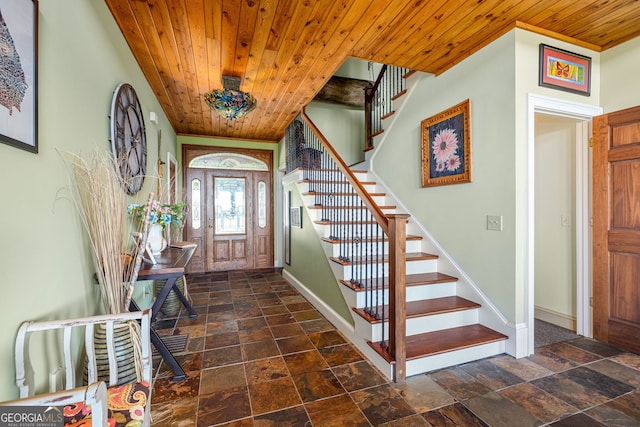 foyer featuring wood ceiling, stone finish floor, and stairway