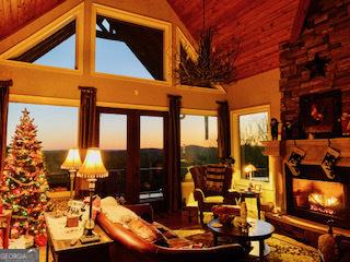 sunroom with lofted ceiling and a lit fireplace