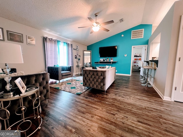 living area with ceiling fan, vaulted ceiling, wood finished floors, and visible vents