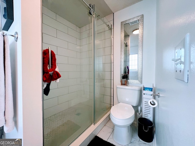 bathroom with a shower stall and toilet