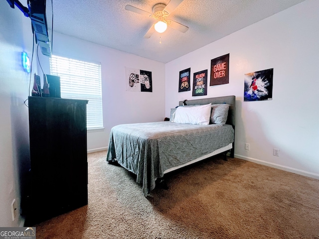 carpeted bedroom with ceiling fan, baseboards, and a textured ceiling